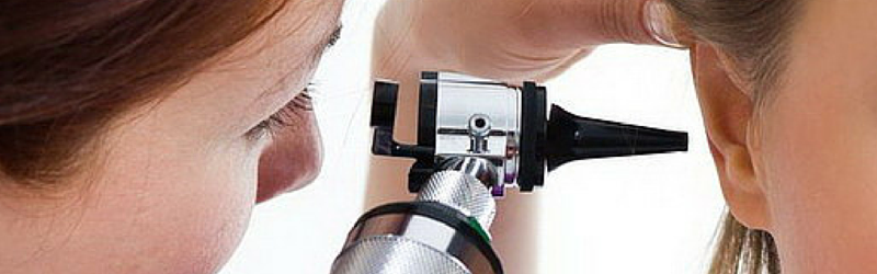Otoscopia. Una dottoressa esamina l'interno dell'orecchio di un paziente