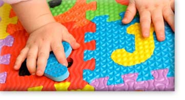 Bambino che gioca su un tappeto morbido fatto a puzzle