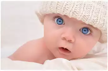 Bambino con gli occhi azzurri con un cappello di lana bianco