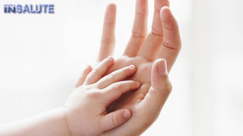 Una mano di bimbo che si appoggia sulla mano della mamma